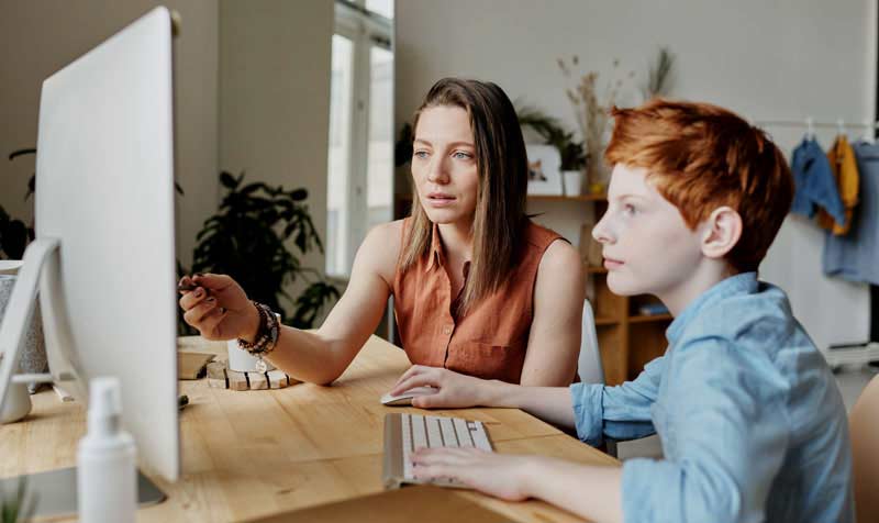 Mentor guiding a learner at a computer